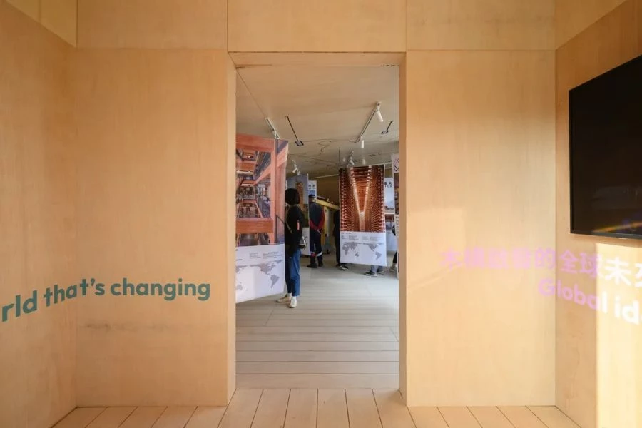 展館位於嘉義市政府對面,整體以方形庭院為核心,其量體造型源自團隊對嘉義木構建築的在地研究。四個導角量體呼應城市街角常見的咖啡館與餐館;四個立面的屋頂線條,則取材自具代表性的木構建築,如博物館與派出所。三側設有通往庭院的入口,室內的粉彩色調亦呼應原始建築的色彩語彙,使其成為一處友善而開放的城市客廳。