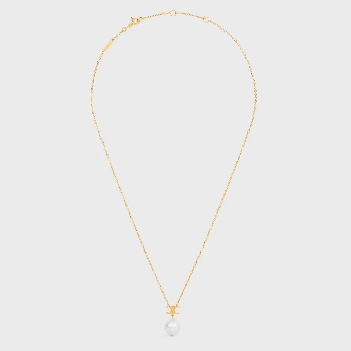 Celine 的 Les Perles 項鍊,以簡潔乾淨的線條彰顯品牌一貫的冷調極簡。中央的 Triomphe 凱旋門吊墜,是品牌最具代表性的符號之一,與下方的一顆圓形樹脂珍珠相連,簡單卻意味深長。