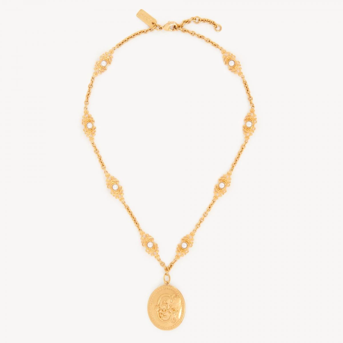 Chloé 的 Château Treasures 項鍊,帶著一種宛如從古董珠寶盒中取出的浪漫氣息。復古金色黃銅鏈條上鑲嵌了「C」字花朵徽章,並點綴上小巧的樹脂珍珠,層層堆疊出女性柔美的姿態。