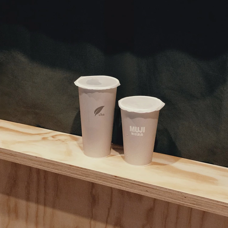 無印良品在微風松高開手間飲料店，綠色櫥窗前擺著兩杯灰色瓶身的手搖杯。