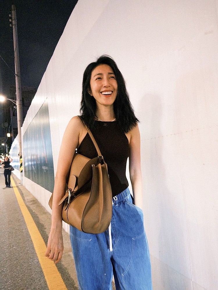 在韓國街頭,楊謹華以一身黑色削肩背心展現健康美,微露的肩頸線條與自然笑容相呼應,下身搭配寬版牛仔褲,肩背上Delvaux Brillant Tempo包款,柔軟而隨性的垂墜感,營造出不經意的時髦態度,更讓Threads上網友熱議!