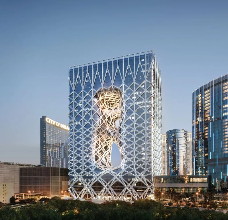 摩珀斯承襲建築大師 Zaha Hadid 的設計美學，將兩棟飯店主量體透過流動曲線相互連結，弱化視覺厚重感。清透的幾何玻璃帷幕，藉由白色鋼構的柔和包裹，賦予建築詩意與張力。40 米挑高的大廳與寬敞跨距成為光影變化的核心舞台。完工後，摩珀斯成為澳門重量級新地標。放眼亞洲，Zaha Hadid 團隊亦在台灣打造「淡江大橋」，在香港設計「The Henderson」商辦大樓，展現建築未來感與雕塑語彙。