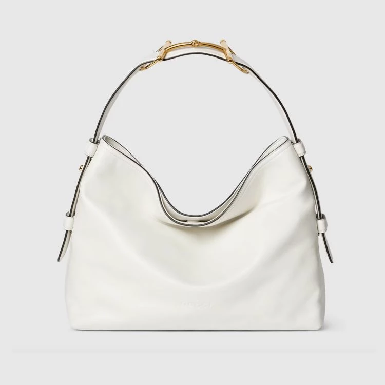 Gucci Beatrix托特包流暢垂墜的袋身輪廓讓大容量包款也能維持優雅姿態,標誌性的金色馬銜扣被重新運用於肩帶結構上,為整體增添一筆低調卻辨識度極高的亮點。
