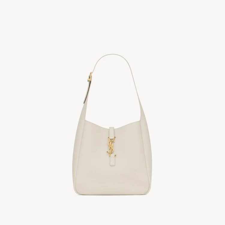 Saint Laurent LE 5 À 7 Soft 托特包精細粒面皮革搭配同色系麂皮內襯,低調卻極富質感。立體翻蓋線條與中央皮革束帶展現Saint Laurent一貫的俐落語言,而金色Cassandre標誌點綴在肩帶上,使整體多了一份雋永的亮點。