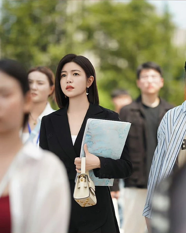 俐落剪裁的西裝外套撐起女強人氣場,但版型上修身反而讓整體線條更顯俐落年輕,黑色的西裝為主軸,配件上她搭配Valentino 2Way mini 奶油白手提包,用明亮淺色中和黑色的成熟感,加上耳際再點綴一對蝴蝶耳環,瞬間替造型注入清新氣息!