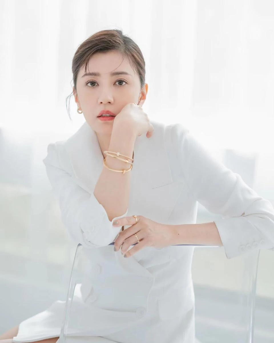 全白西裝套裝本身就極度考驗氣質,一不小心就容易顯得過於正式或距離感十足,但賈靜雯巧妙地用珠寶替造型注入溫度。她選擇以 Tiffany & Co. 的高級珠寶作為點綴,溫潤的金屬光澤在白色布料映襯下顯得格外柔和,也讓整體視覺多了一層層次。金色不張揚,卻能自然提亮膚色,讓全白造型看起來更有精神。這樣的搭配不靠繁複設計取勝,而是以簡潔線條與質感珠寶完成收尾,成熟卻不顯老,反而流露出一種從容而自信的減齡魅力。