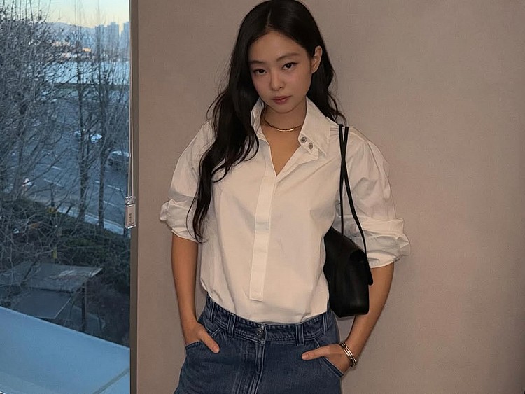 Jennie以一件Chanel白襯衫示範她最擅長的「鬆弛型時髦」。襯衫刻意不全扣、袖口自然捲起，搭配直筒牛仔褲，讓學院感單品轉為率性日常。