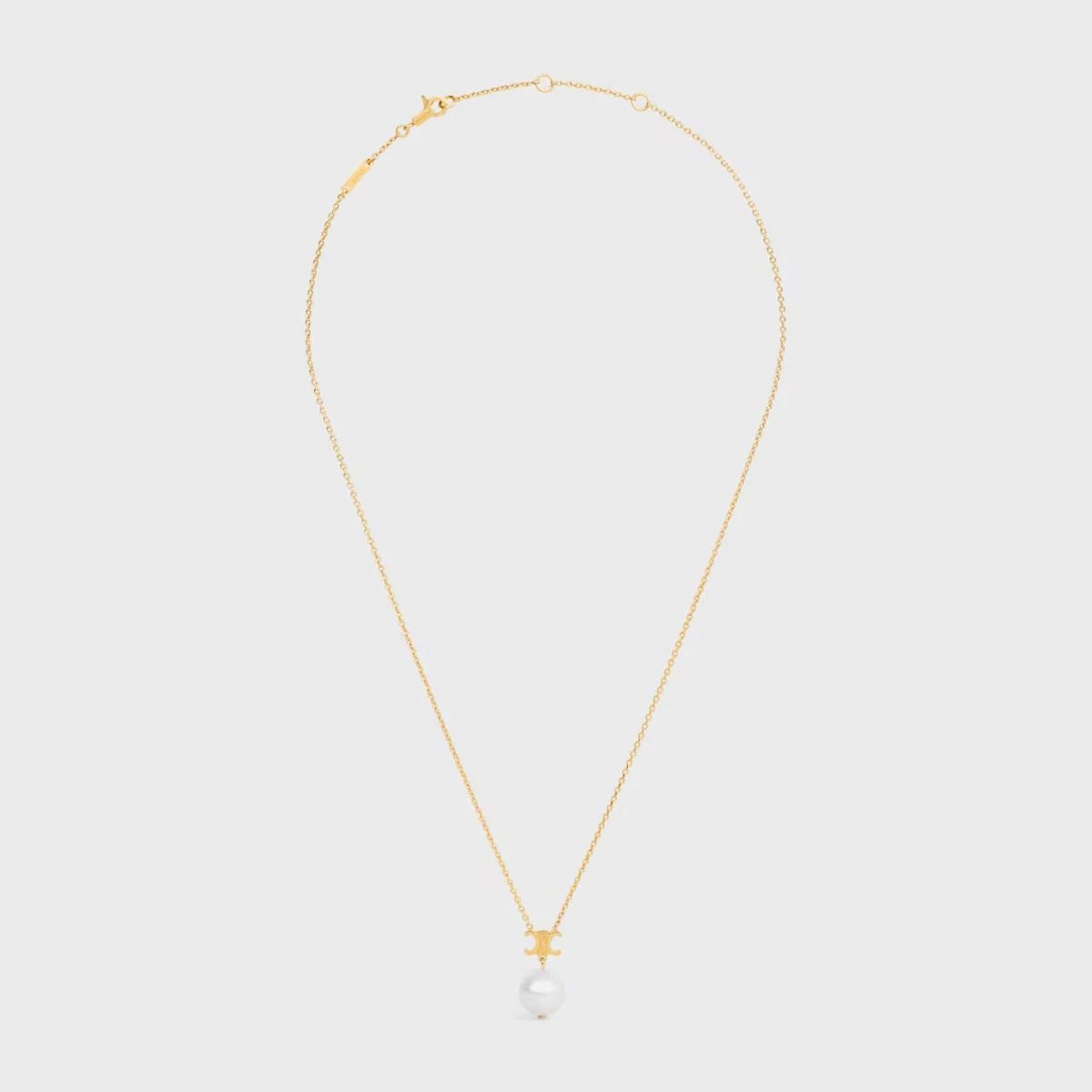Celine 的 Les Perles Celine 項鍊以樹脂珍珠搭配金色飾面黃銅，墜有品牌象徵性的 Triomphe 凱旋門標誌。極簡線條、乾淨比例，沒有多餘裝飾，卻能在每一次轉身間閃爍微光。兩萬元內的入手價，更讓它成為小資族最值得投資的日常精品之一。