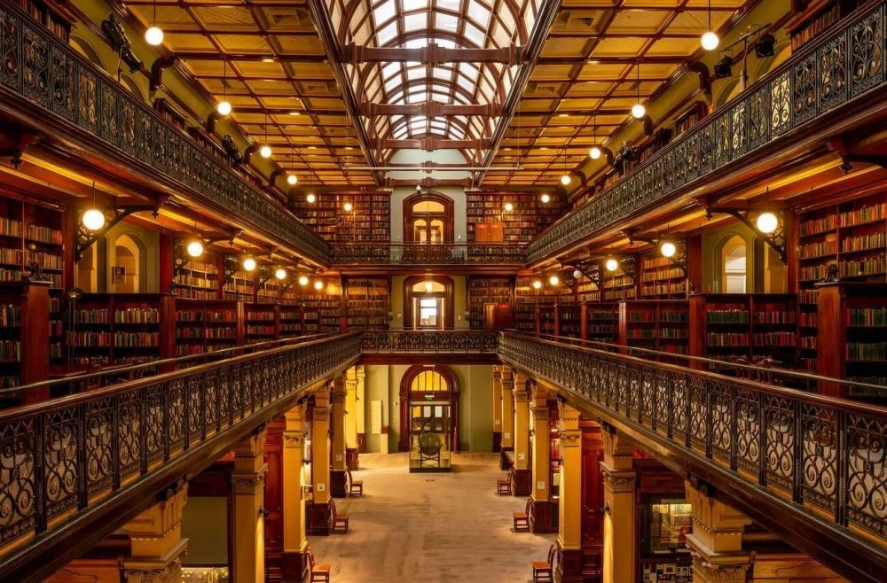 坐落於澳洲的阿德雷德市中心,南澳州立圖書館(State Library of South Australia)自 1836 年成立以來,以華麗的維多利亞建築風格,以及珍貴的歷史典藏,被評選為全球十大最美圖書館。空間,是這座圖書館最大的迷人之處,令人驚嘆的拱頂天窗,讓整座圖書館沐浴於柔和天光之中,散發超凡脫俗的典雅氣息。穿梭其中,彷彿置身古典文學的黃金美好年代。