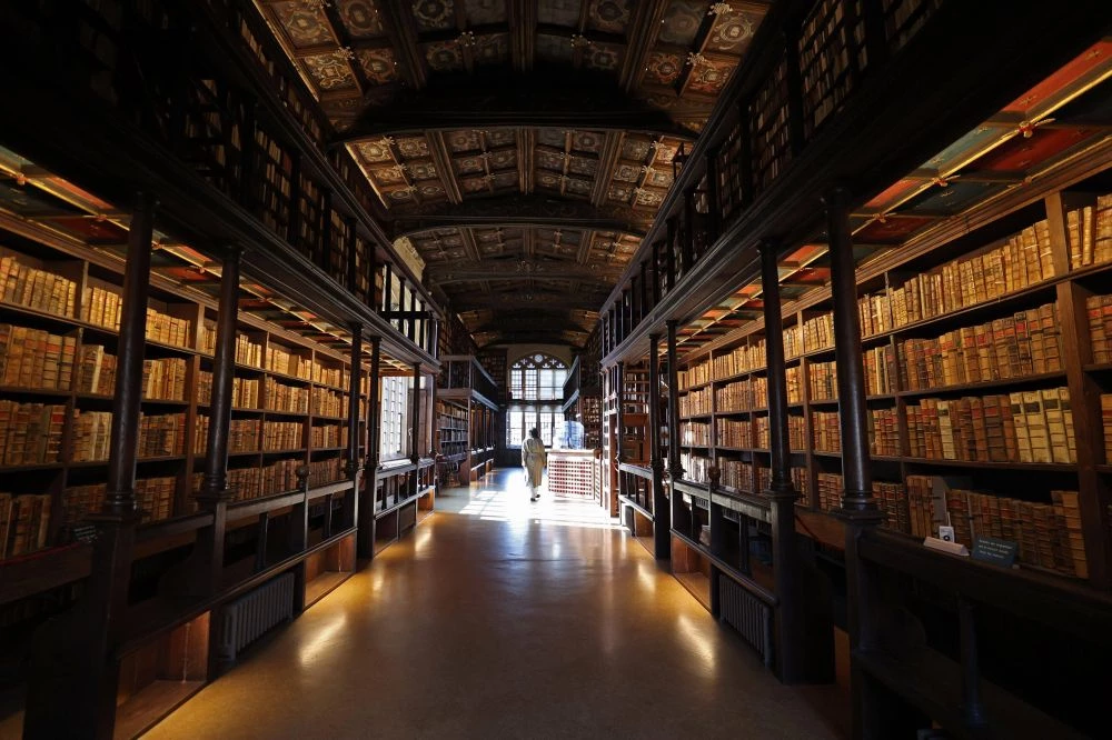作為牛津大學博德利圖書館(Bodleian Library)中,最古老的閱覽室, 漢弗萊公爵圖書館(Duke Humfrey’s Library)的歷史可追溯至 15 世紀。圖書館曾在宗教改革期間失去大部分藏書,後於 16 世紀末由托馬斯・博德利爵士(Sir Thomas Bodley)重建並重新開放,至今,館內依舊保留著原始橡木書架與手繪天花板,歷史氛圍濃厚,亦是古典學術殿堂的象徵。