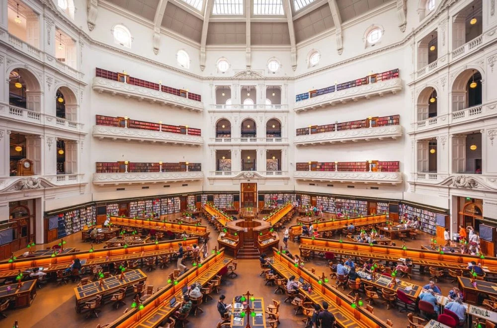 成立於 1854 年的維多利亞州立圖書館(State Library Victoria),是澳洲歷史最悠久的公共圖書館之一,也是全球最早對大眾免費開放的圖書館先驅之一。圖書館本體採新古典主義風格設計,入口氣派的柱廊與科林斯柱式建築令人印象深刻。不只外觀壯麗,館區規模也龐大,佔據墨爾本市中心街區,橫跨超過 23 棟彼此相連的建築,展現新舊交融的建築美學。