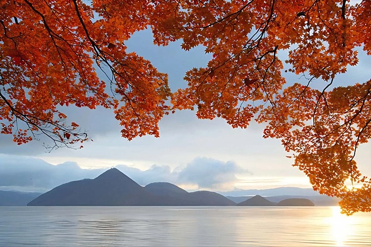 位於北海道虻田郡的洞爺湖，是一座由火山口形成的圓形湖泊，湖水澄澈如鏡，倒映著四季變幻的天光。