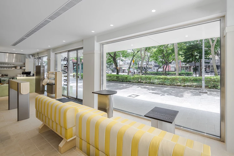 Ouvert Seoul插旗台北,全新店面由 UUU DESIGN INC. 操刀,純白建築搭配大片落地窗,將戶外綠意與咖啡香氣一併引入空間,營造簡約卻不失溫度的氛圍。