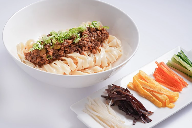 「炸醬麵」則展現截然不同的性格，肉醬濃郁卻不膩口，五種配料讓口感更有變化，醬香與麵體取得恰好的平衡，熟悉卻不老派。