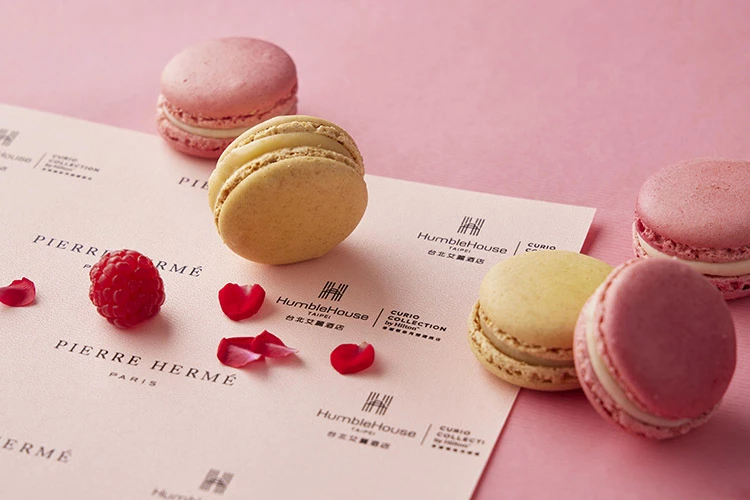 提到Pierre Hermé,自然不能錯過被譽為「甜點界畢卡索」最經典的代表作—馬卡龍(Macaron)。本次午茶組收錄兩款人氣口味:「ISPAHAN玫瑰荔枝與覆盆子馬卡龍」,融合花香、果香與果酸層次,像是一場法式花果盛宴;而「百香果馬卡龍」則以酸甜果香勾勒熱帶氣息,酥脆外殼搭配柔滑內餡,每一口都是幸福的重量。
