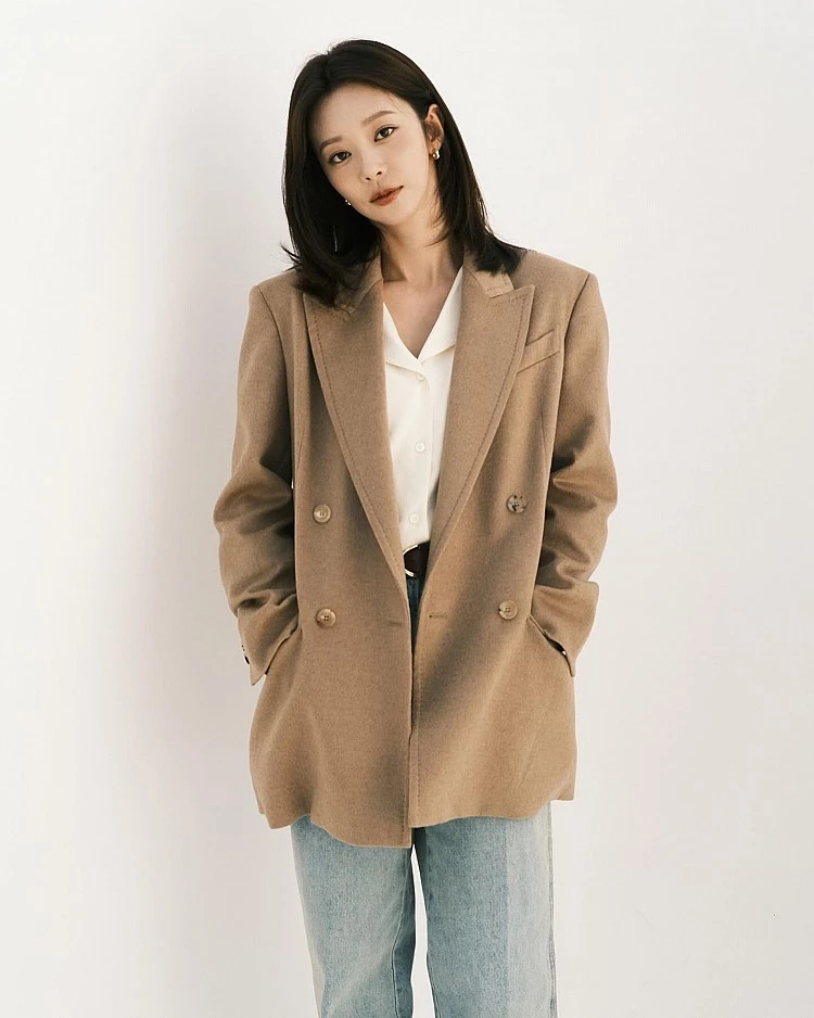 向來以「職場女性制服教科書」聞名的 Max Mara,近年持續替經典西裝外套注入更柔軟、也更貼近日常的輪廓。李主儐這套造型選擇的,正是品牌近年備受討論的 Olimpia 駝色羊毛西裝外套,採用雙排扣設計,內搭簡約白襯衫、下身搭配牛仔褲,刻意用日常單品中和西裝的正式感。