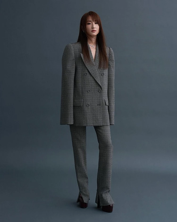 柯佳嬿出席金鐘獎的這套成套西裝，來自Acne Studios，意透過比例與細節削弱傳統正裝的嚴肅感。西裝外套肩線俐落、衣長偏長，營造修長線條，下身長褲以微喇剪裁搭配開衩設計，讓整體在行走間更顯輕盈。
