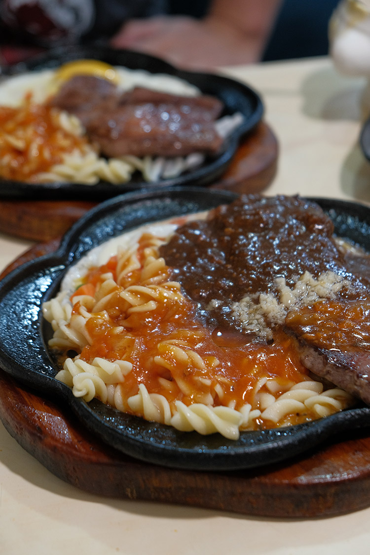 在廣州街夜市的熱鬧裡，「皇后牛排館」從路邊攤起家到如今有冷氣座位，價格依舊親民，味道始終熟悉。