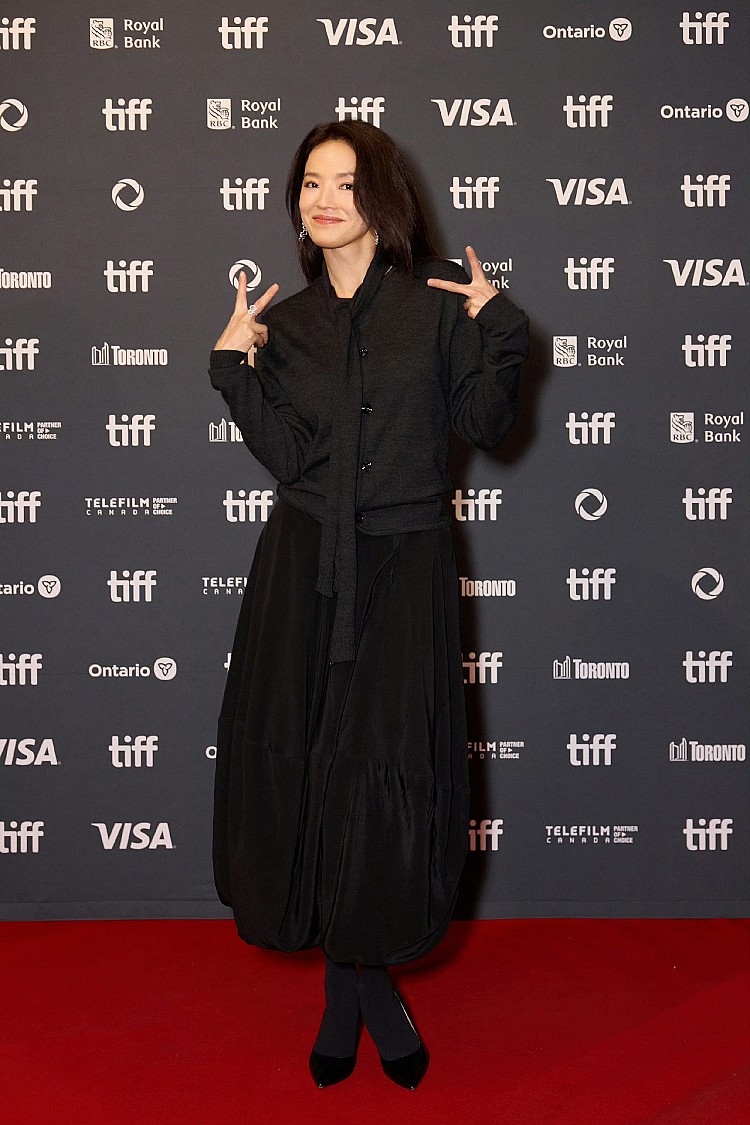 在多倫多影展選擇了一身低調卻高質感的黑色系穿搭,她身穿Lemaire黑色開襟衫搭配上同品牌中長裙,線條俐落又帶點慵懶,整體輪廓修飾得優雅大方,配件部分,她選擇 Qeelin鑽石耳環與戒指 作為點綴,讓沉穩的黑色調中帶出微光,巧妙平衡剛柔氛圍。