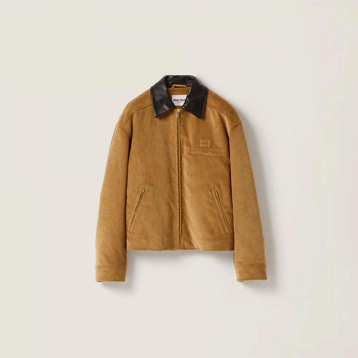Miu Miu 以燈芯絨面料賦予 Barn Jacket 柔軟細膩的氣質,搭配對比皮革領口與輕盈填充設計,打造出俐落又具女性化的輪廓。復古與現代的衝突感,正是品牌獨到的迷人所在。