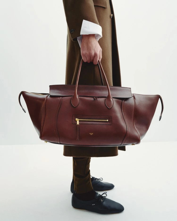 全新登場的Celine New Luggage手袋系列，以標誌性的梯形輪廓融入橫向比例，採用柔軟亮澤的小羊皮或絨面牛皮打造，內襯以黏合結構製成，讓包袋內外都呈現一致的細膩觸感。