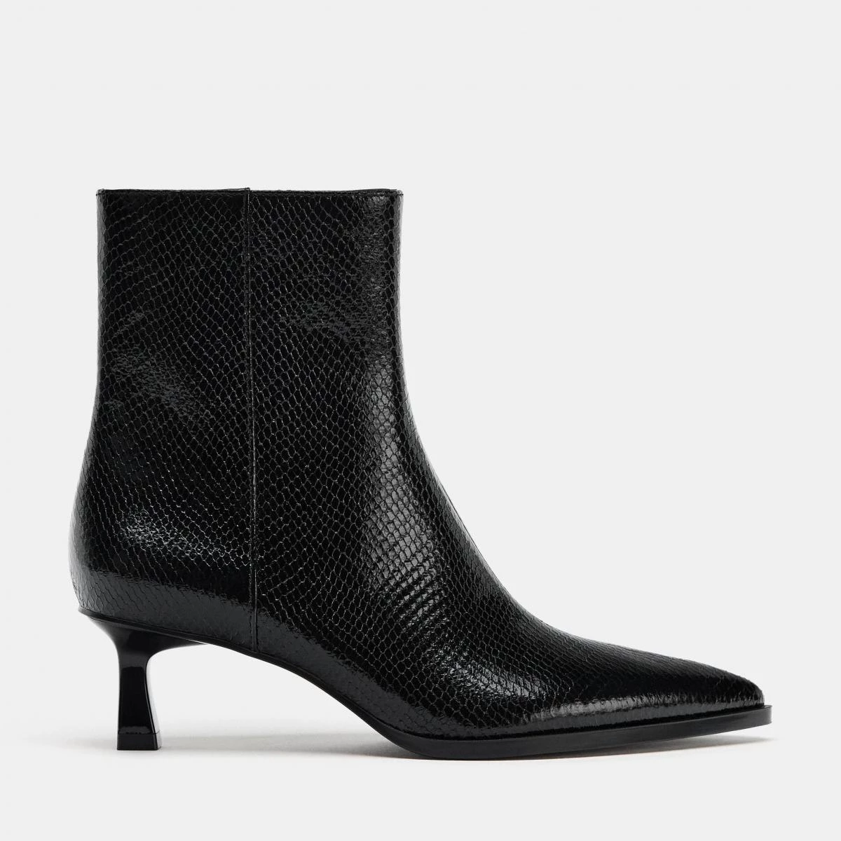 Zara 這雙浮雕中跟踝靴,屬於第一眼低調、第二眼有細節的款式。仿蛇皮浮雕為全黑輪廓增加層次,卻不會過於張揚,對於日常通勤或需要一點氣場的場合特別友善。尖頭設計自然拉長腿部線條,5.5公分的小貓跟高度恰到好處,既有修身效果,又不會讓行走變得吃力。側拉鍊讓穿脫俐落省時,搭配西裝褲、直筒牛仔或長裙都能成立。如果你正在找一雙百搭的黑色跟靴,這雙是安全卻不無聊的選擇。