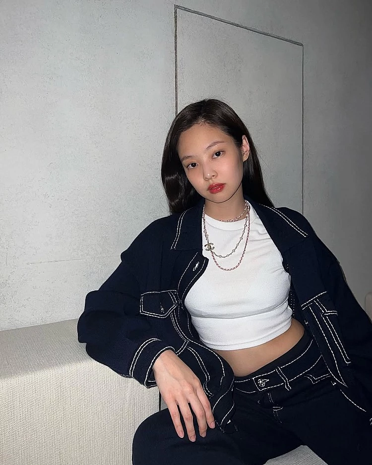 結構感對比也是Jennie穿搭中的強項。利用白色合身短版上衣作為內層基底,俐落勾勒身形線條,外搭深色牛仔襯衫與同色系下身,透過明顯白色車線強化輪廓存在感,讓整體在率性中保有精緻度。