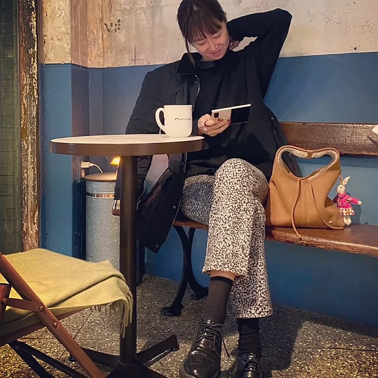以全黑上身作為基底，刻意選擇寬鬆剪裁的工裝外套，沒有強調身形線條，反而讓肩線與袖長自然垂落，只是隨性披著，讓整體層次更柔軟。