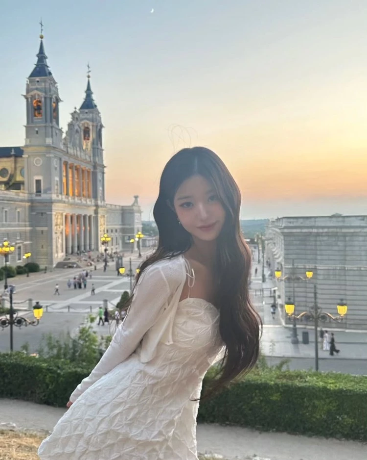 上身以皺摺感勾勒出微微立體的輪廓線條,細肩帶與針織罩衫則增添柔和感與少女氣息,搭配自然波浪長髮與清透妝容,更能襯托白潤的膚色。