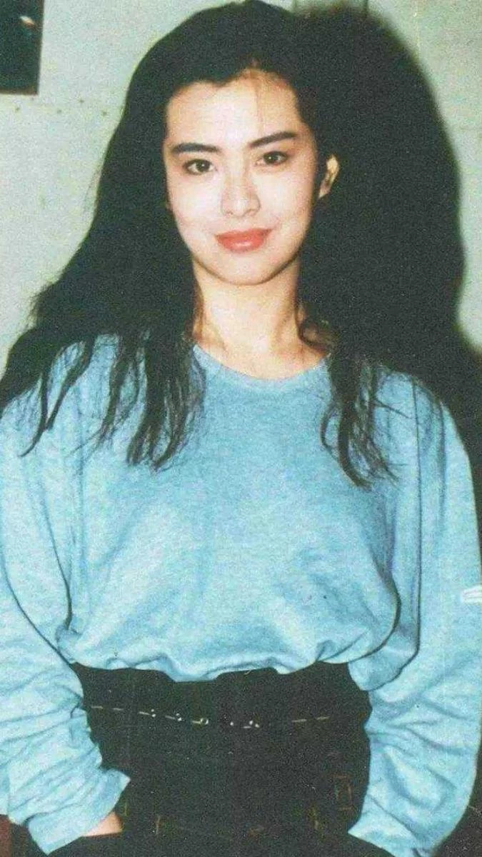 這套造型把90年代的休閒感穿得很有態度。淺藍色大學T版型寬鬆，色調柔和，讓整體氣質顯得輕鬆、不具侵略性；下身搭配黑色高腰褲，立刻穩住重心，也讓身形比例更集中俐落。真正的亮點落在腰間的銀色腰鍊，低調卻醒目，在休閒與個性之間拉出一道界線，讓看似簡單的搭配多了一道時尚層次。這種「基本款＋關鍵配件」的穿法，不靠誇張取勝，卻很有記憶點，即使放到現在，依然是街頭與日常穿搭中非常好用的穿搭技巧。