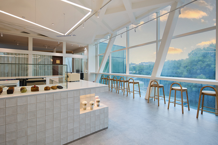 台北市立美術館｜Rolling Dough 空間僅有12 席的小巧座位，延續館體的現代線條與通透採光，臨窗座位能看見低空航道，讓「喝咖啡看飛機畫過天空」畫面成真。