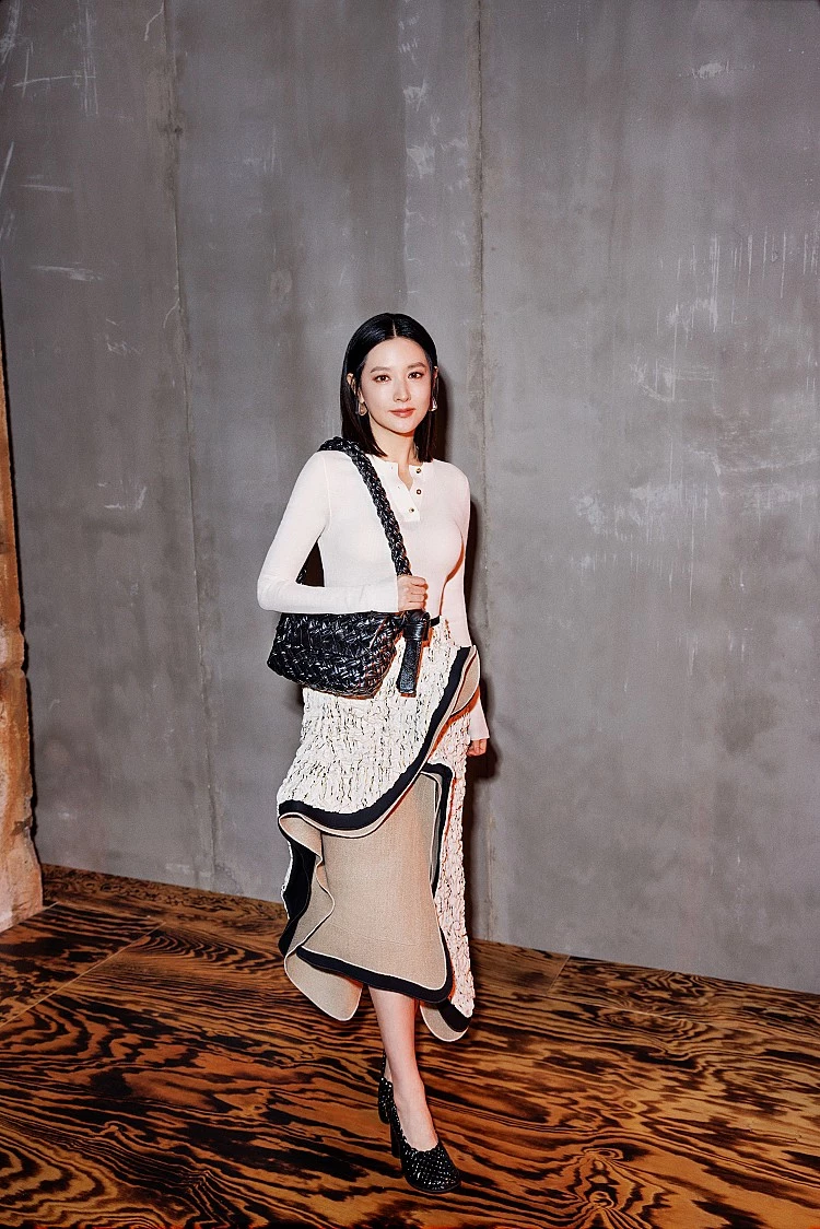 李英愛現身Bottega Veneta 2024秋冬大秀上，依舊展現出她「凍齡女神」的風采，選擇白色針織上衣，貼合身形卻不過分緊繃，乾淨俐落的線條映襯白皙膚色，更顯透亮光澤。下身搭配一件充滿層次感與流動感的長裙，不規則剪裁在行走間散發優雅韻律，為整體增添設計感，呼應腳上的黑色鏤空高跟鞋，剛柔並濟。