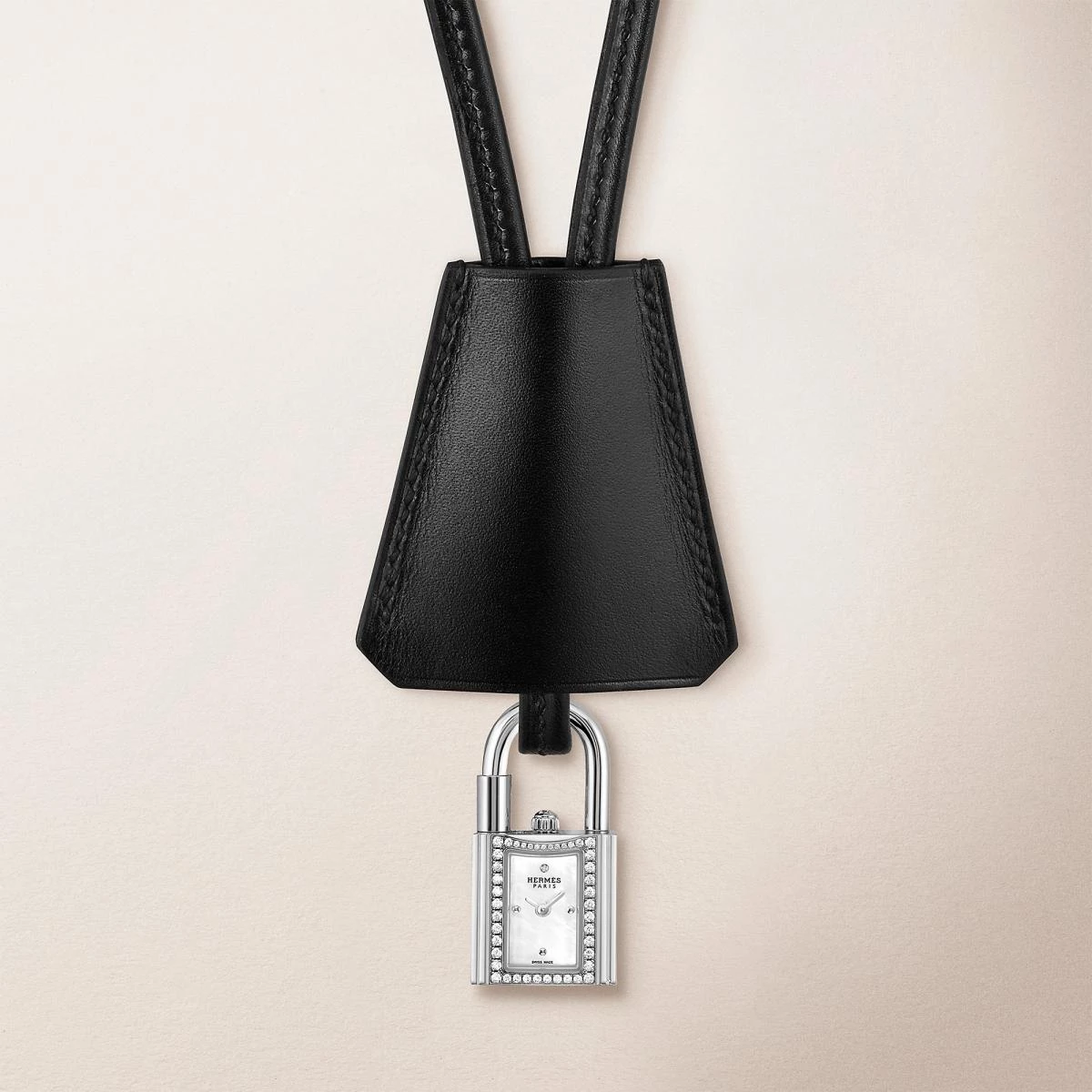 Hermès 的 Kelly 錶是對品牌傳奇手袋的一次巧妙致敬。以鎖頭造型化身為迷你時計,16毫米的精鋼鑲鑽錶殼懸於頸間或繫於腕上,既俏皮又高雅。