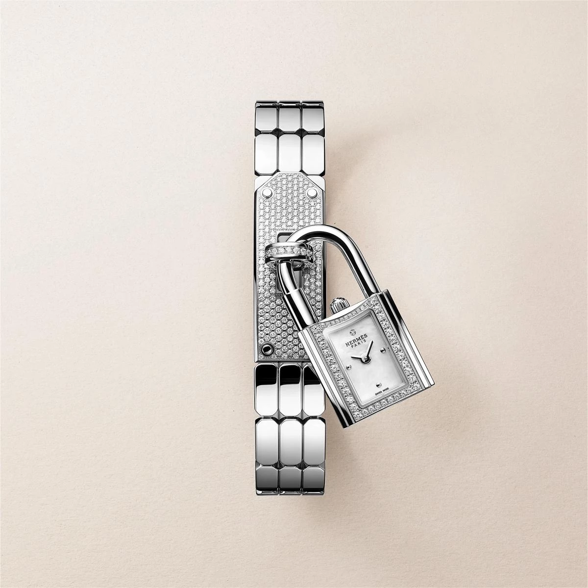 Hermès 的 Kelly 錶是對品牌傳奇手袋的一次巧妙致敬。以鎖頭造型化身為迷你時計,16毫米的精鋼鑲鑽錶殼懸於頸間或繫於腕上,既俏皮又高雅。