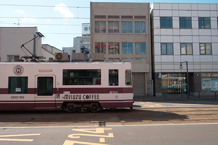 在函館的街上,有輛寫著「美鈴珈琲」的路面電車,人們都叫它「美鈴號」。編號8101的它為了慶祝品牌90週年重返街頭,慢慢穿過城市巷弄。