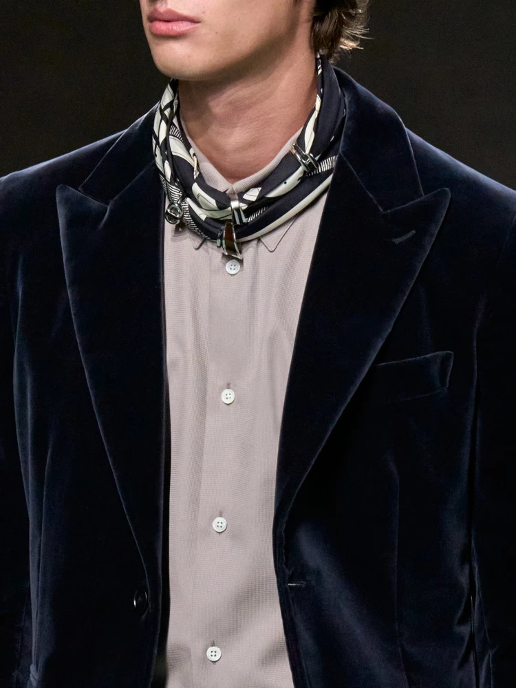愛馬仕2025秋冬男裝秀亮點：絲巾是 Hermès DNA 中無法被忽略的單品，在本季秋冬男裝秀裡依舊成為最穩定卻又畫龍點睛的配件，這次不僅細緻滾邊、印花邊框等變化多端，打法是自己DIY把戒指穿過，再繞頸後作為裝飾，俐落有型又溫柔。