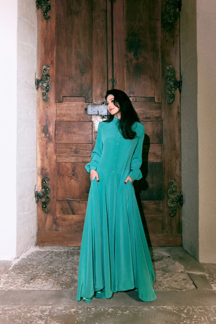 舒淇以導演身份受邀法國盧米埃電影節，一身高級訂製的飄逸洋裝，藍綠色的絲絨質感，襯衫領結合飄逸長裙的剪裁設計，完美修飾比例又散發知性氣息，顏色上更是映襯雪白肌膚與紅唇，更添減齡明亮感。配件上她選用Roger Vivier綠色緞面高跟鞋，並點綴上Cartier獵豹珠寶為整體造型增添華麗感。