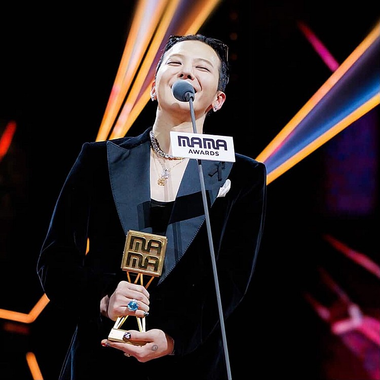 2025  MAMA 頒獎典禮時隔 7 年回歸香港舉辦，這次則由「K-pop 王者」G-Dragon 拿下最大獎「年度藝人獎」，而這次獎項由香港影帝周潤發頒發，恰巧十年前周潤發也是頒發此獎項給 G-Dragon，兩人不只開心擁抱，還俏皮的牽起手共跳一段〈TOO BAD〉，引起全場尖叫聲不斷。