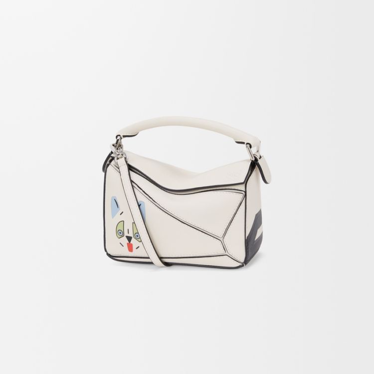 Loewe Puzzle Mini以標誌性的幾何切割線條呈現立體輪廓，延續品牌最具辨識度的建築感美學。雲舞白包身上加入皮革鑲嵌工藝描繪的「未來主義貓咪」圖案，趣味又帶點藝術感。