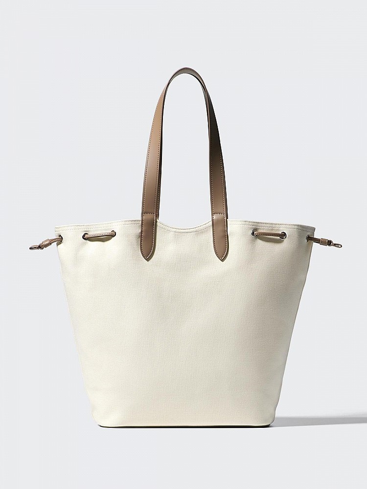 有著帆布、合成皮革異材質拼接，包身以帆布材質為主，搭配合成皮革提把與細節點綴，不只視覺更有層次，也讓整體風格從休閒感直接升級為「通勤友善」。相較全皮革托特包，重量更輕，長時間提著也不容易肩膀痠，實用度明顯加分。