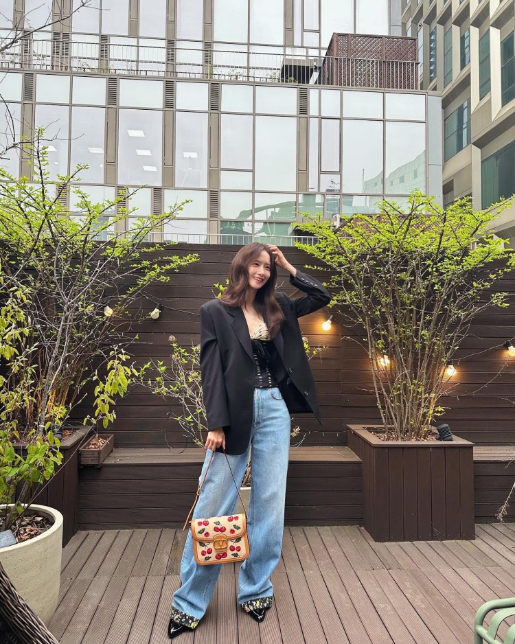 潤娥用黑色Oversized西裝外套搭配內裡緞面Corset上衣，完美平衡酷帥與性感的反差感，拉長腿部線條的同時也中和了上半身的正式感，手拎的Valentino櫻桃編織包，既優雅又有種童趣感！