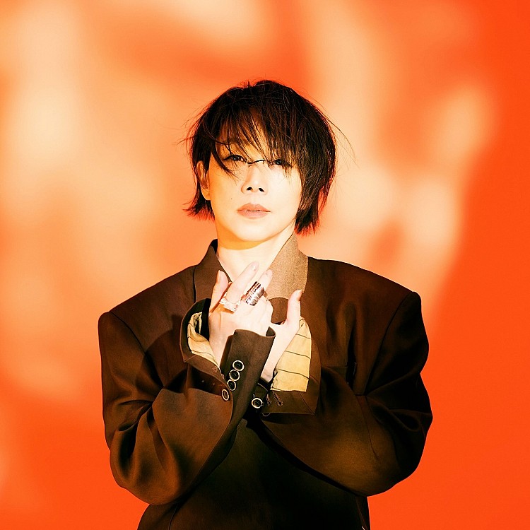 以一身寬肩線條的深色西裝造型，展現林憶蓮強大氣場，落肩的版型並把袖子折上來，讓整體視覺更有層次，而隨性披散的短髮與帶有凌亂感的劉海，則為造型注入不經意的慵懶氛圍，呼應手上多枚金屬戒指堆疊，與寬鬆西裝的比例形成剛柔並濟的對比。