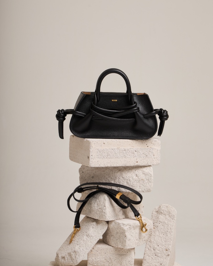 Fundao絕對是近年備受矚目的泰國平價設計品牌，主打手工製作的真皮包款，以質感細膩的皮革搭配獨特的「束身衣式繩結開合設計」聞名，既實用又展現工藝細節，這種不張揚的時髦態度，讓包包不只是潮流配件，更能成為日常輕鬆駕馭的單品！