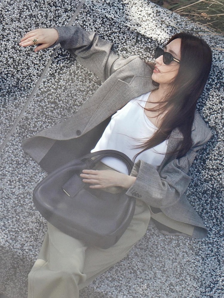 這組造型延續柯佳嬿擅長的日常穿搭路線，Bottega Veneta灰色西裝外套版型偏寬鬆，帶有點布料混紡的質地，內搭白色上衣與開心果綠長褲，透過乾淨配色弱化西裝的正式感，整體顯得輕盈而從容。