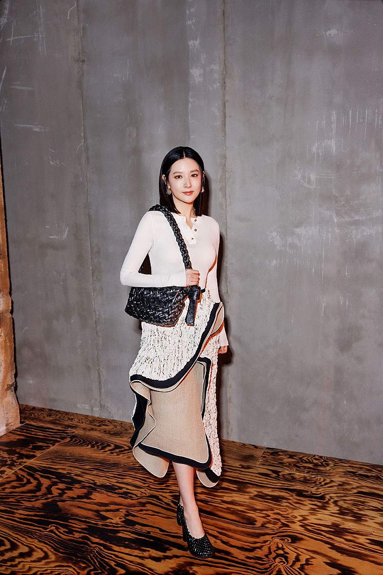 李英愛現身Bottega Veneta 2024秋冬大秀上，依舊展現出她「凍齡女神」的風采，選擇白色針織上衣，貼合身形卻不過分緊繃，乾淨俐落的線條映襯白皙膚色，更顯透亮光澤。下身搭配一件充滿層次感與流動感的長裙，不規則剪裁在行走間散發優雅韻律，為整體增添設計感，呼應腳上的黑色鏤空高跟鞋，剛柔並濟。