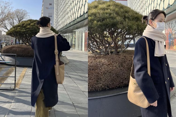 這一套金高銀穿上深藍色長版大衣，版型不刻意收腰，反而保留一點空氣感，讓整體看起來從容、不緊繃。內搭簡單、色調克制，重點放在米色圍巾與駝色Chanel肩背包的層次銜接，柔和地打破深色大衣的距離感。金高銀把「正式感」穿得很生活，不是精心打扮的街拍，而是走在街上也合理、耐看的搭配。