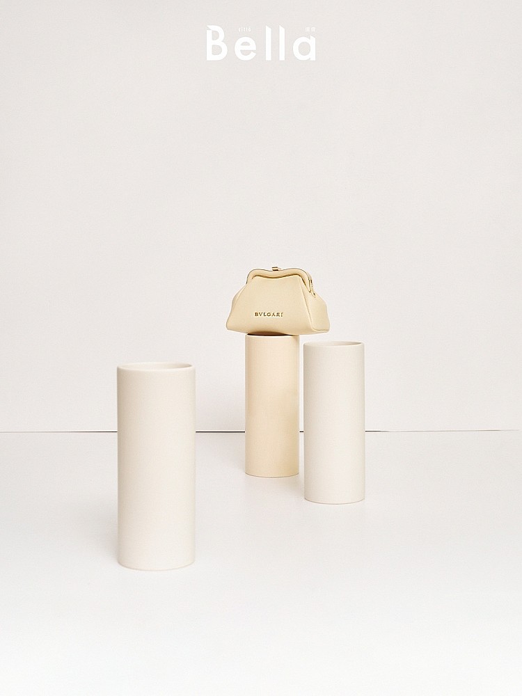 此圖為來自Bvlgari的奶油白「Serpentine Pouch」小巧澎潤的口金造型鏈條零錢包，造型復古、優雅的手拿包再度回籠，成為造型裝扮的最佳利器。
