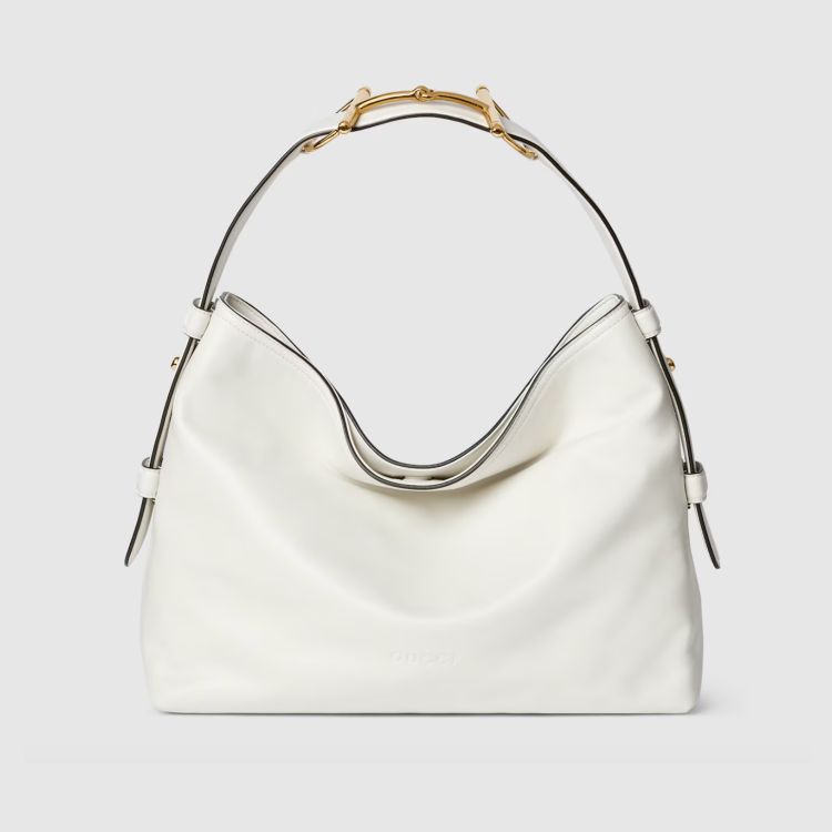 Gucci Beatrix托特包流暢垂墜的袋身輪廓讓大容量包款也能維持優雅姿態，標誌性的金色馬銜扣被重新運用於肩帶結構上，為整體增添一筆低調卻辨識度極高的亮點。