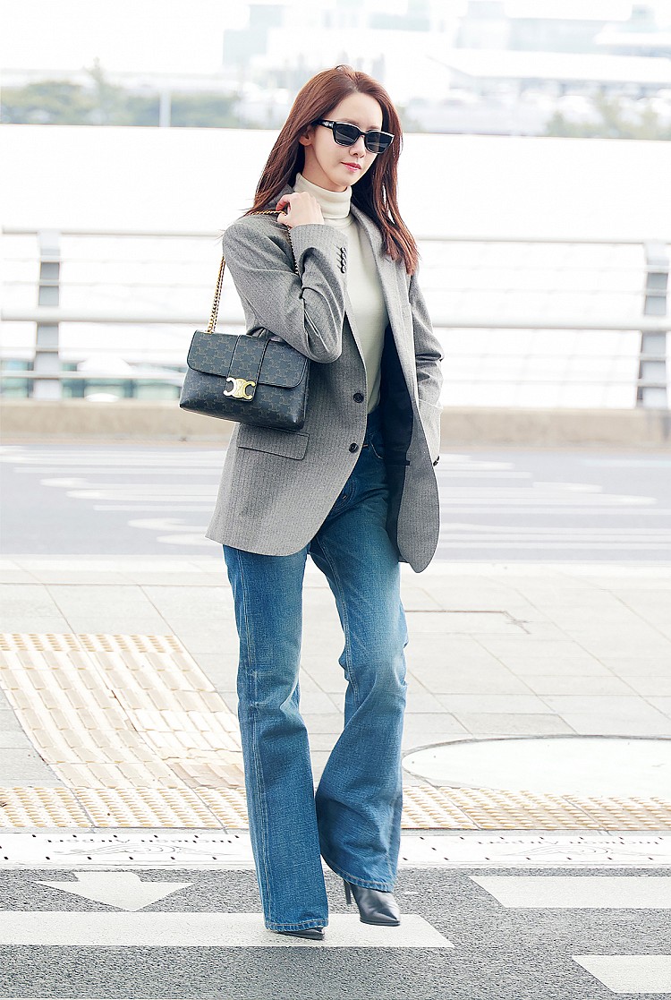 潤娥以一身灰色的法式剪裁西裝外套搭喇叭褲款的牛仔褲，內搭高領白色針織上衣，肩上揹的「Victoire」老花鏈條包，搭配金色鏈帶與標誌性Logo扣環，這套穿搭不僅修飾比例，也成功展現「簡單卻不簡單」的好品味。