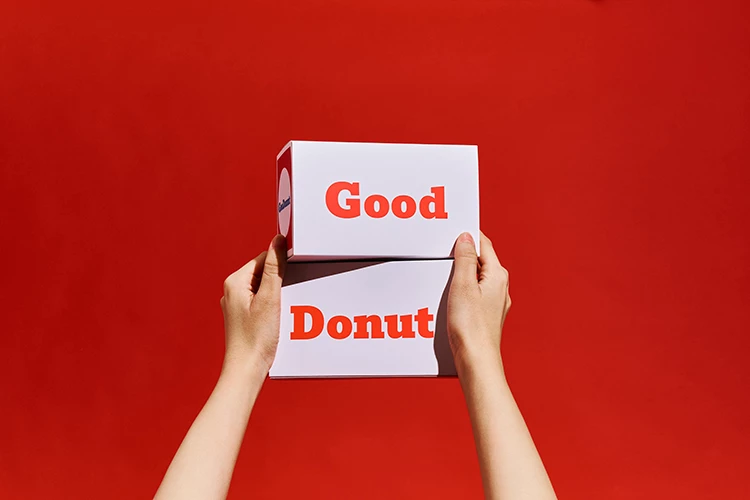 手拿Goodonut經典的紅、白、藍配色的兩個紙盒